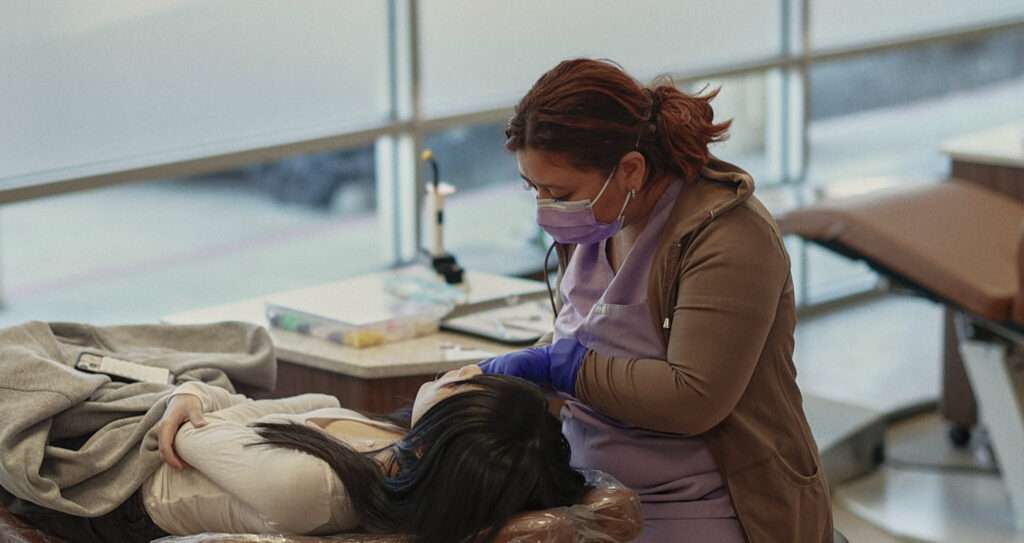 Doctor looking at patient's mouth.